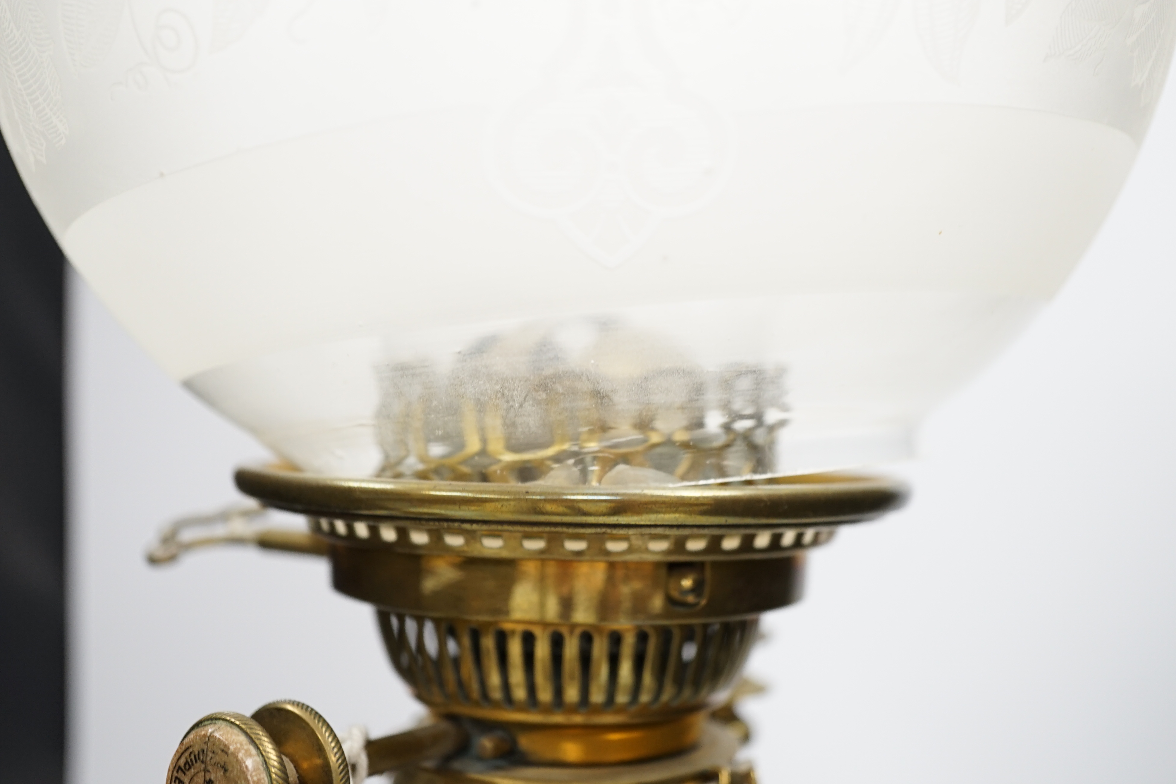 A Victorian brass oil lamp with glass reservoir and etched shade, 70cm high